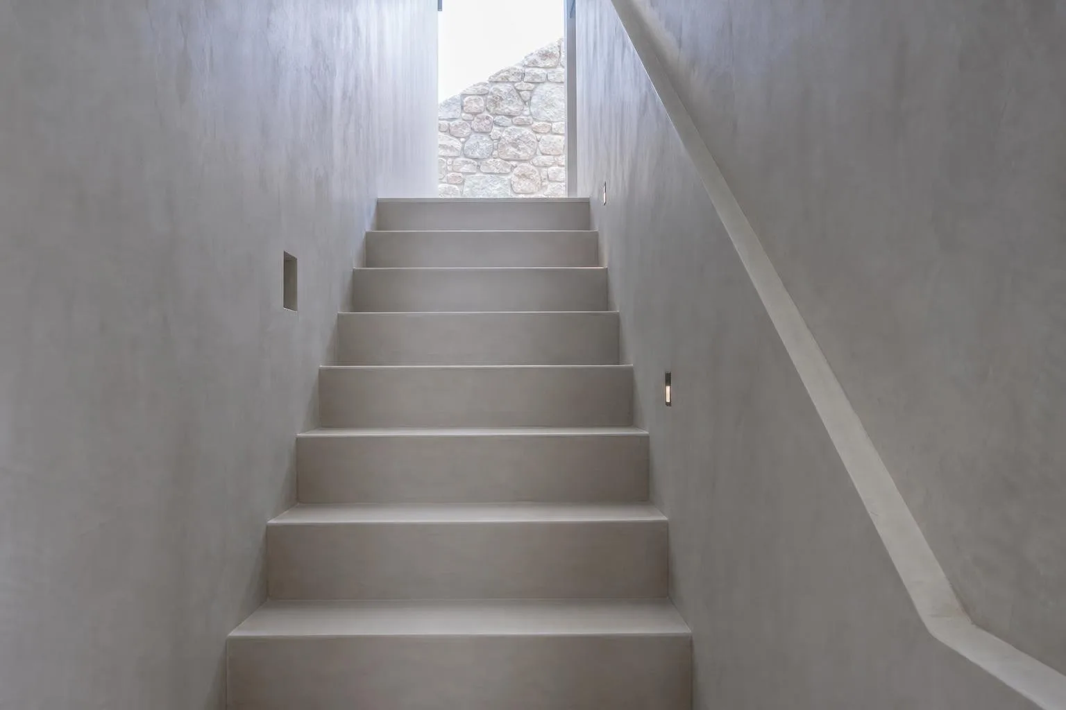 Escalera interior revestida de microcemento gris