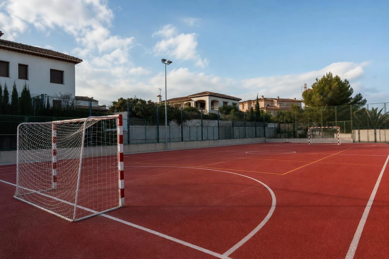 Pista multideporte roja con porterías de fútbol